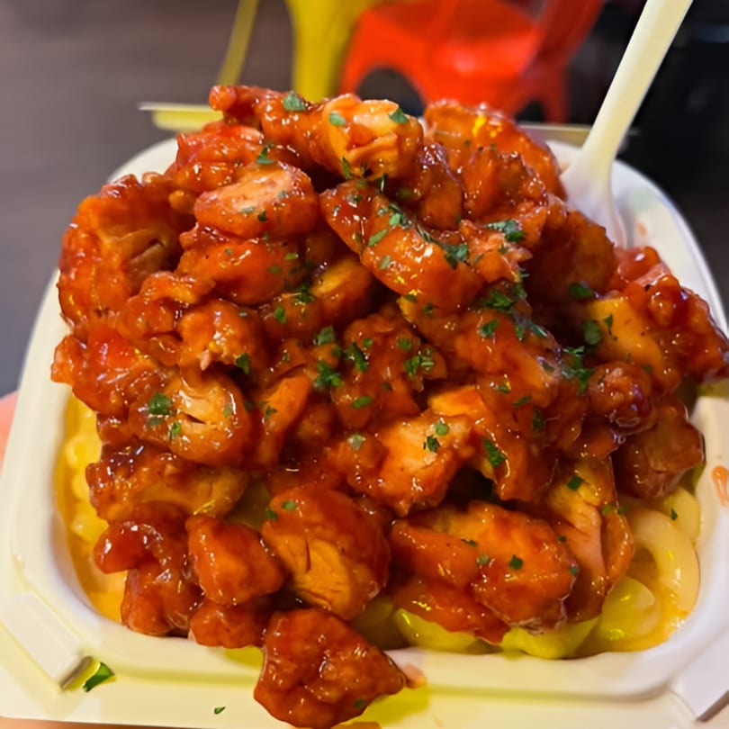 Close-up of Chick Wings and Things' boneless wings, coated in a glossy orange sauce and sprinkled with parsley.